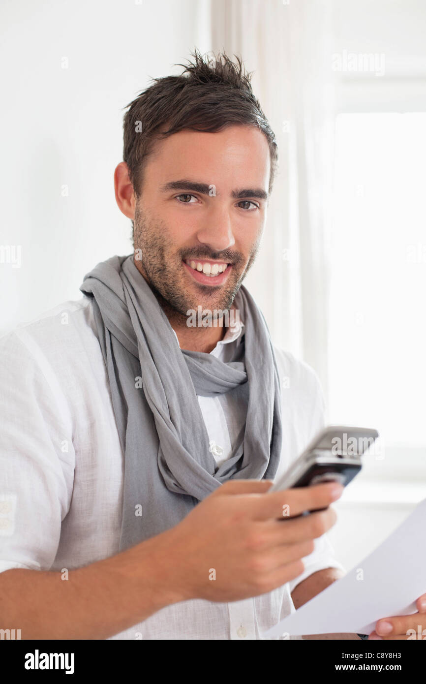 portrait of young man in empty room with mobile phone Stock Photo - Alamy