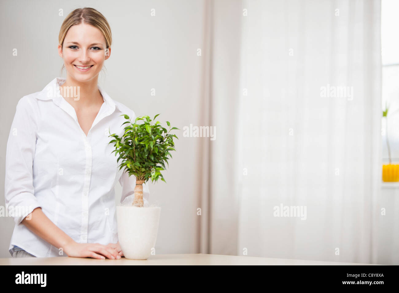 portrait of young woman with potted plant Stock Photo - Alamy