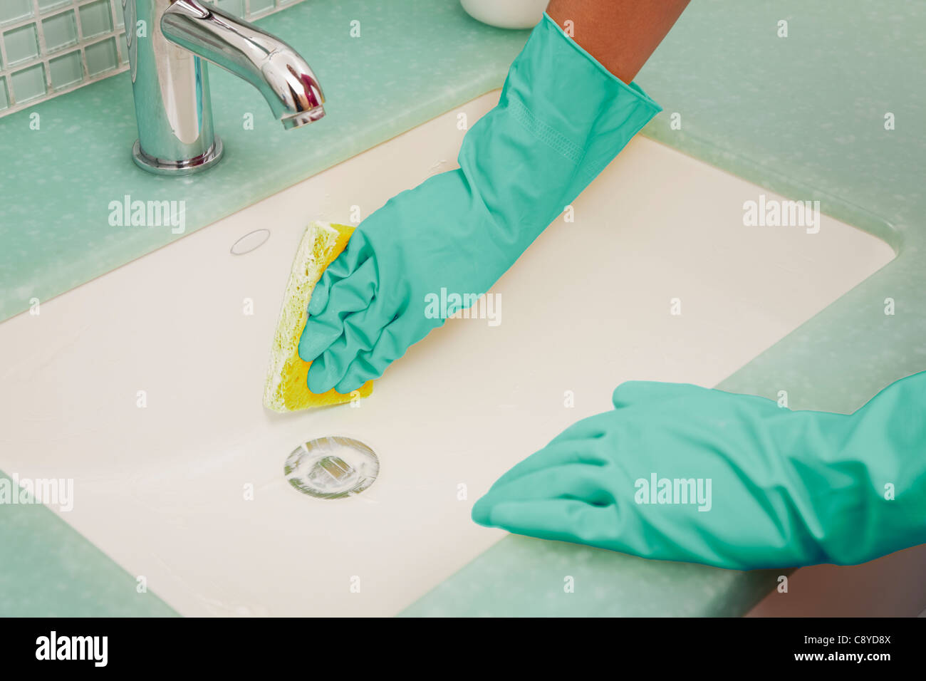 USA, Illinois, Metamora, Close-up of woman in rubber gloves cleaning bathroom sink Stock Photo