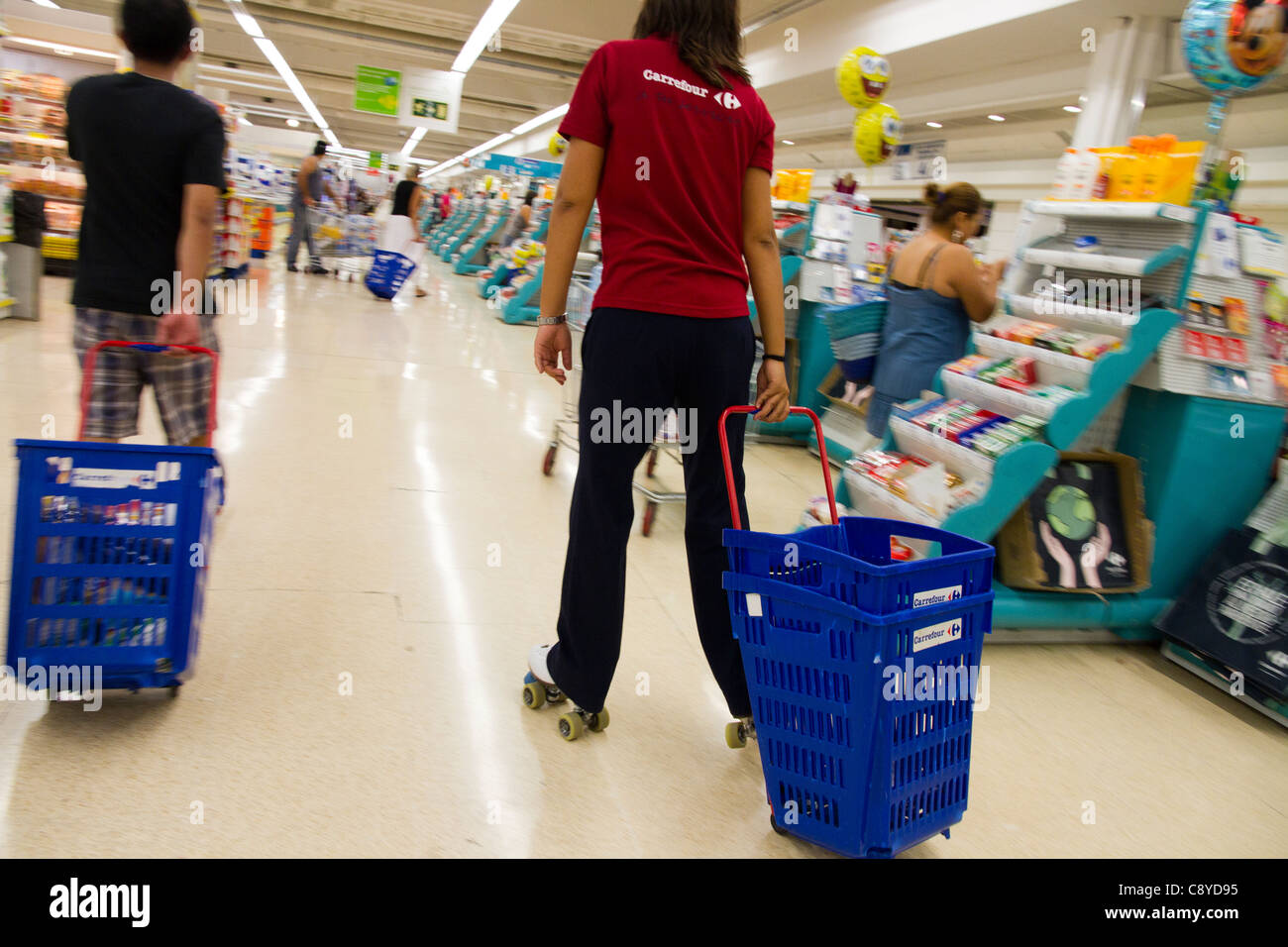 Supermarket worker with shopping basket trollys and Rollerskates in Mallorca  Majorca Spain Stock Photo - Alamy