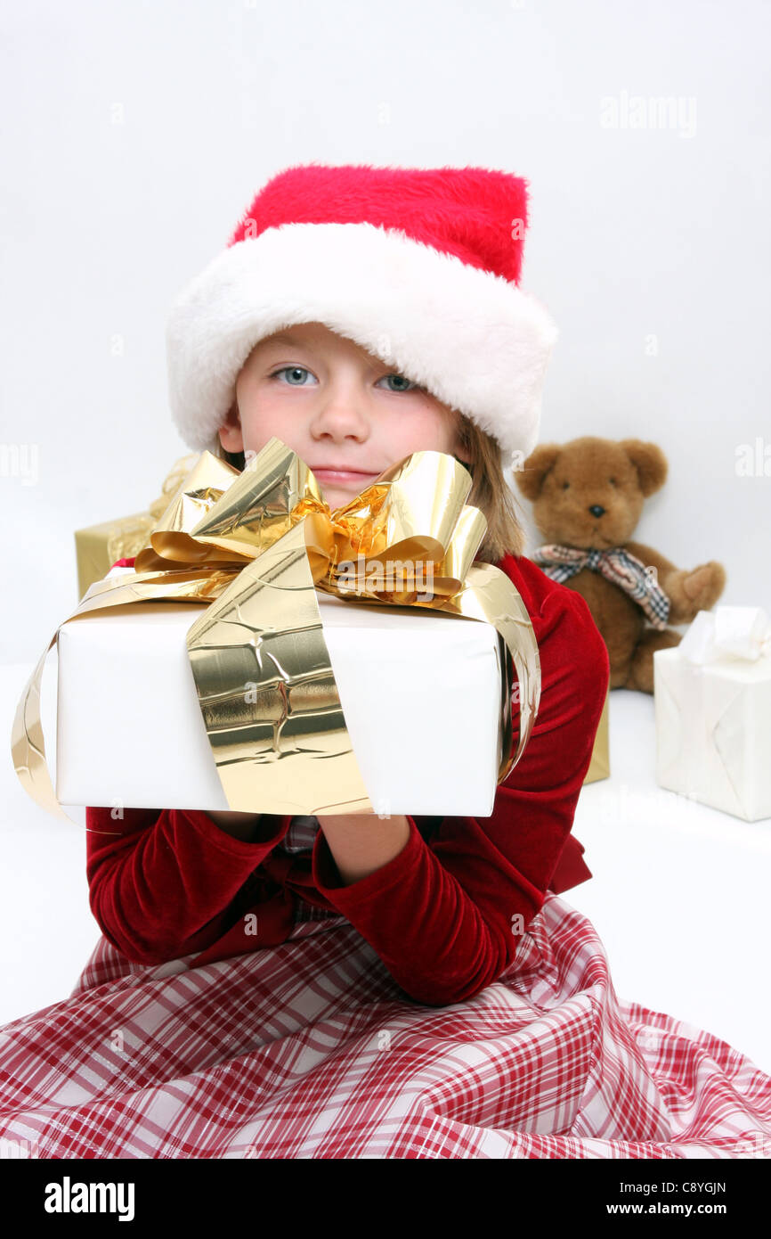 A young girl holding a Christmas present Stock Photo - Alamy