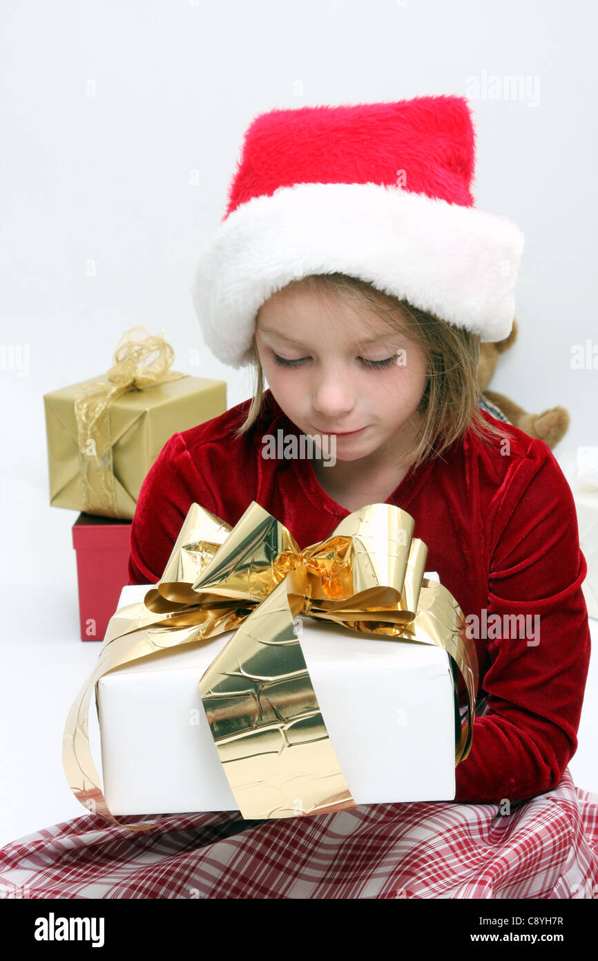 A young girl holding a Christmas present Stock Photo - Alamy