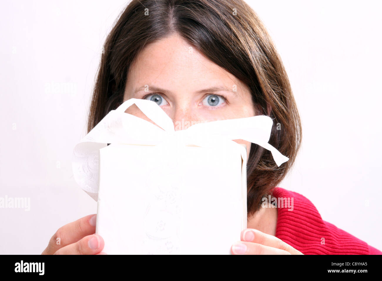 A young woman holding a Christmas present Stock Photo - Alamy