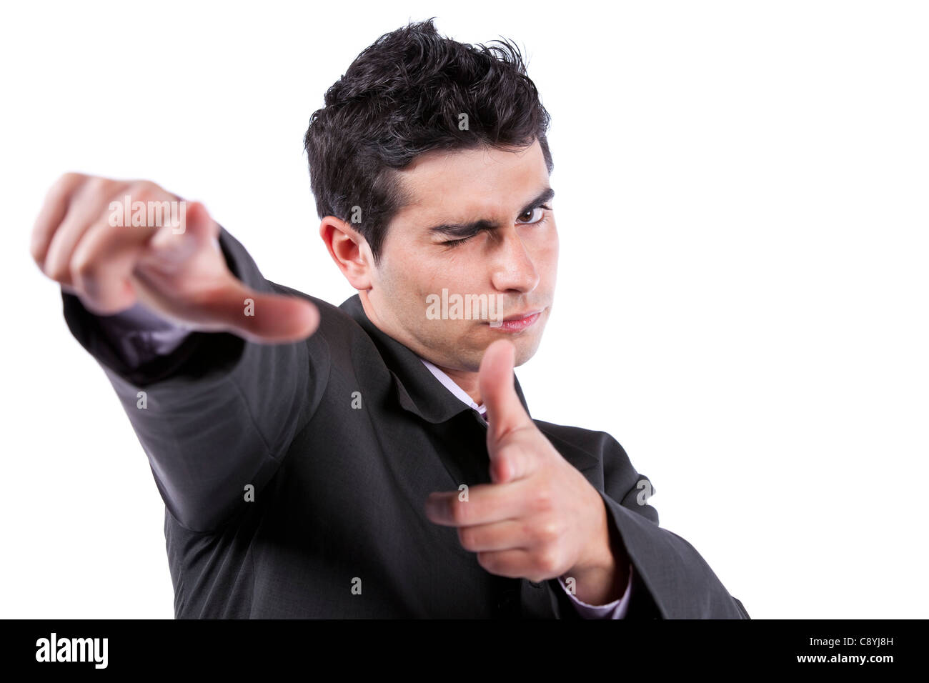 Young businessman blinking his eye and pointing to you (isolated on