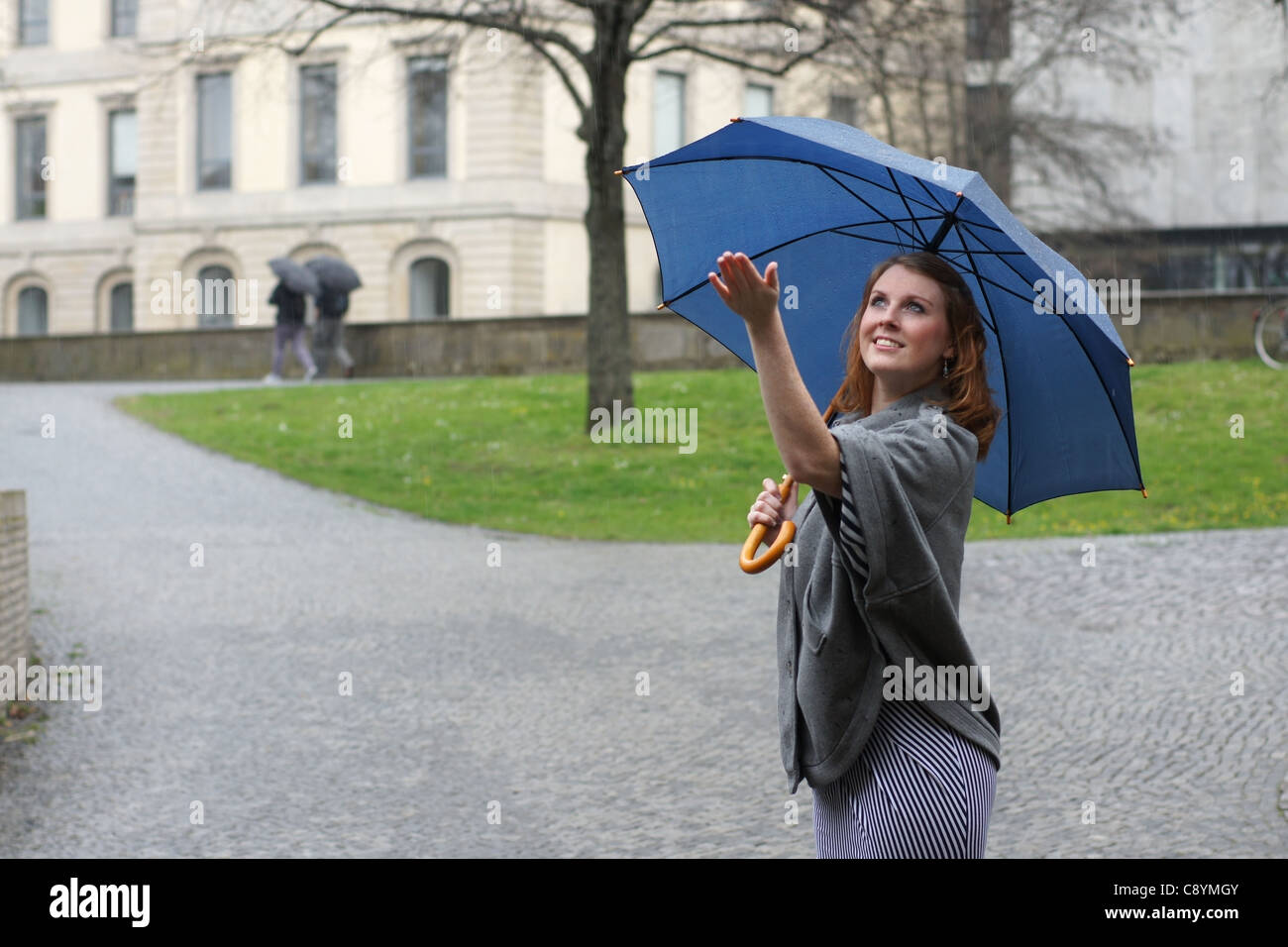young woman with umbrella enjoying the rain Stock Photo