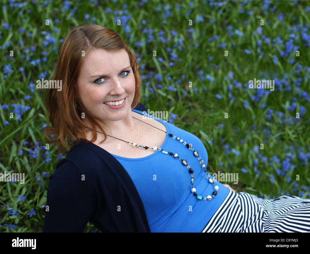 smiling young woman amidst flowers (bluebells) Stock Photo