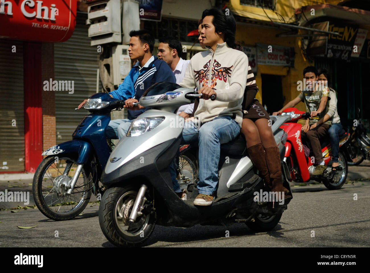 Asia, Vietnam, Hanoi. Hanoi old quarter. Young vietnamese people riding on motorbike through Hanoi.... Stock Photo