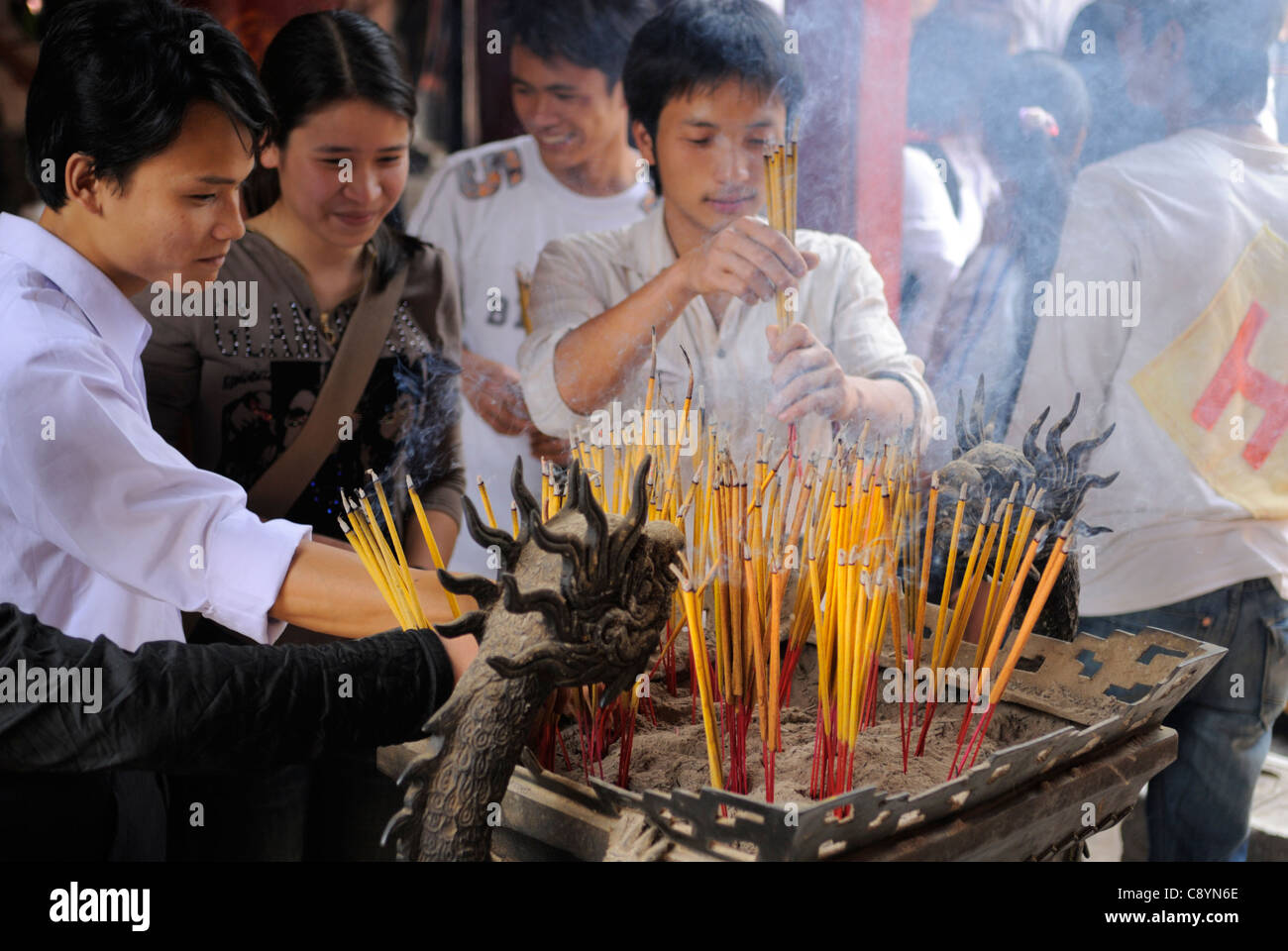 Asia, Vietnam, Hanoi. Temple of Literature (Van Mieu). House of Ceremonies (Bai Duong). Worshipping by burning incense sticks... Stock Photo
