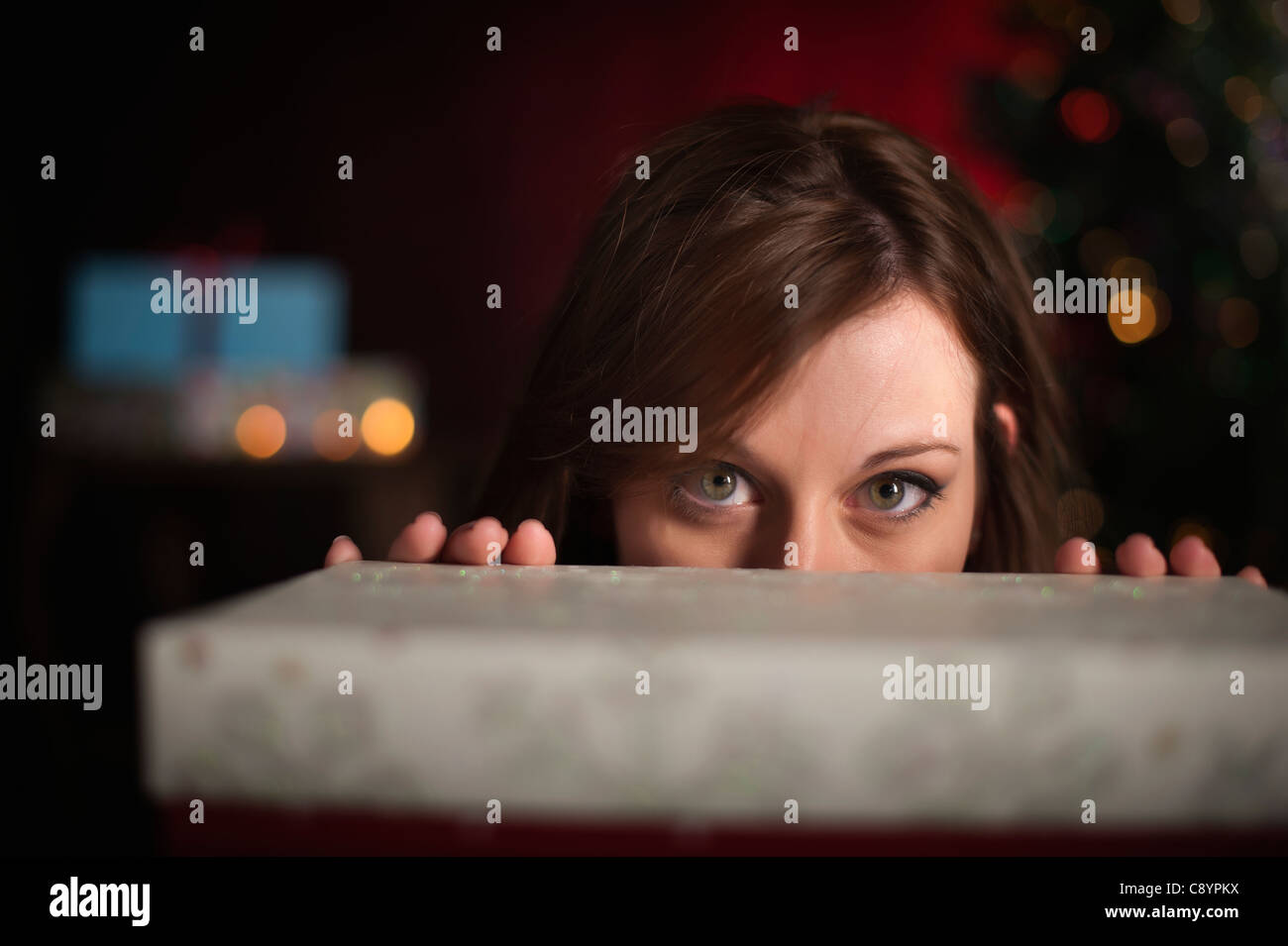 Woman behind gift box at Christmas time Stock Photo