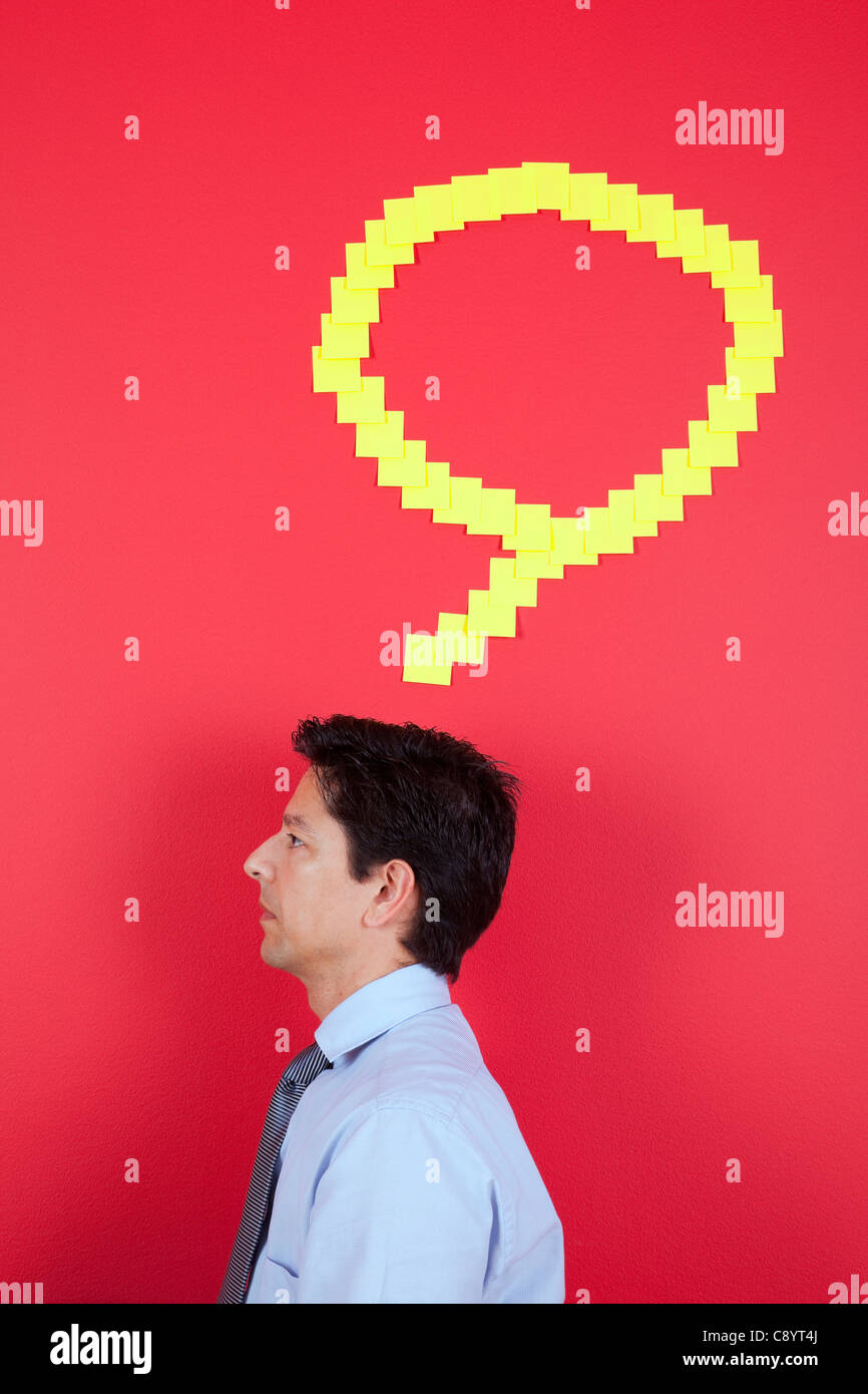 Businessman thinking next to a red wall Stock Photo