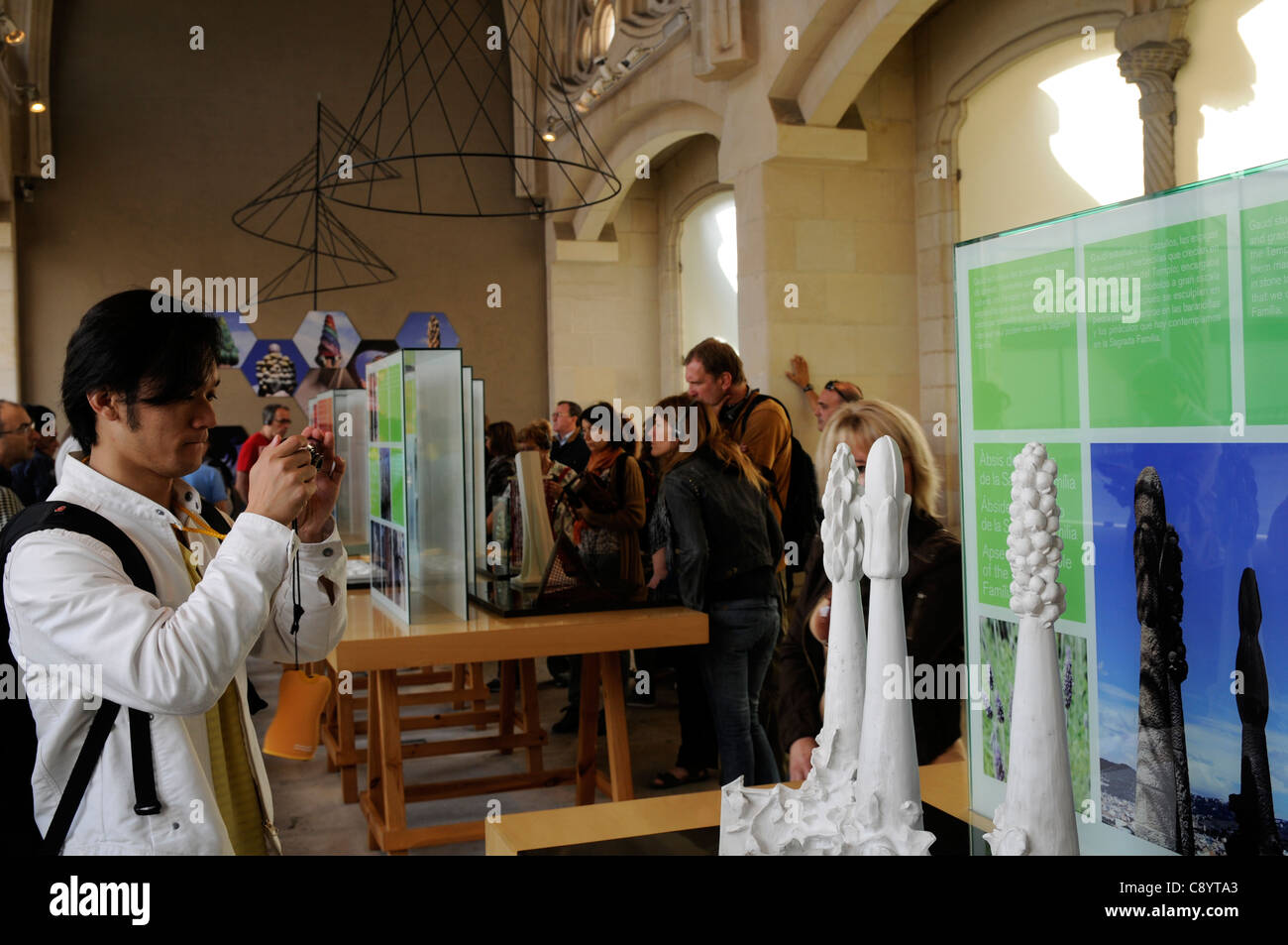 Tourist taking a photo of a model of the towers of the Basílica y Templo Expiatorio de la Sagrada Familia. Barcelona Stock Photo