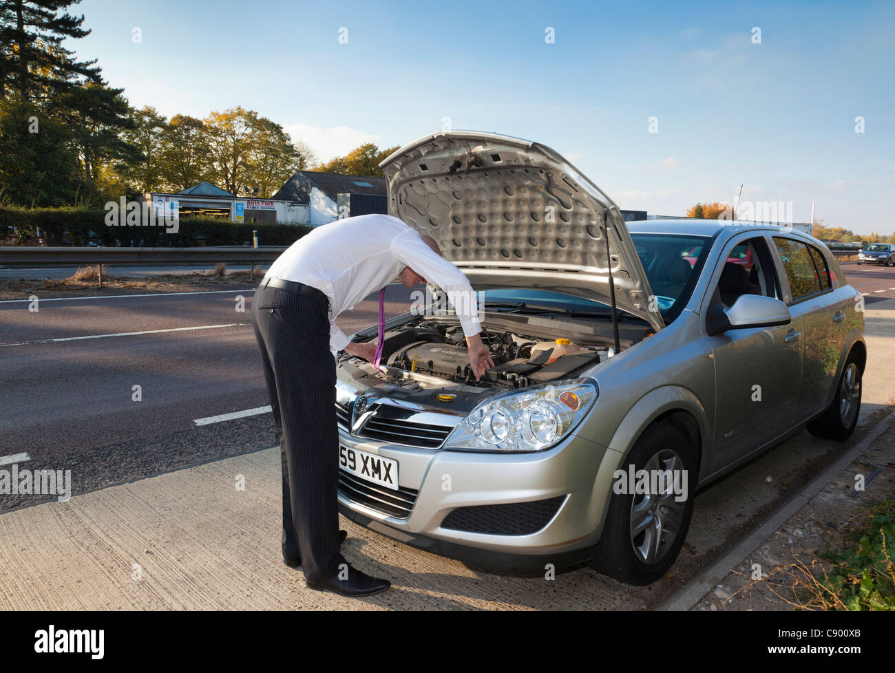 man with broken down car along motorway Stock Photo