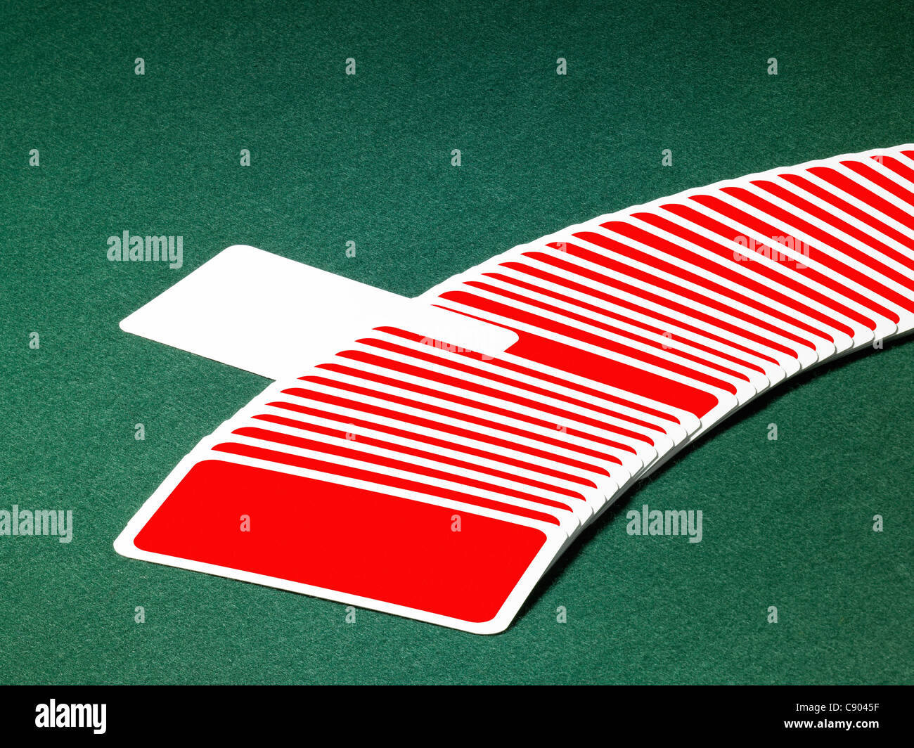 studio photography of spread out playing cards in a row with one chosen, located on green felt background Stock Photo