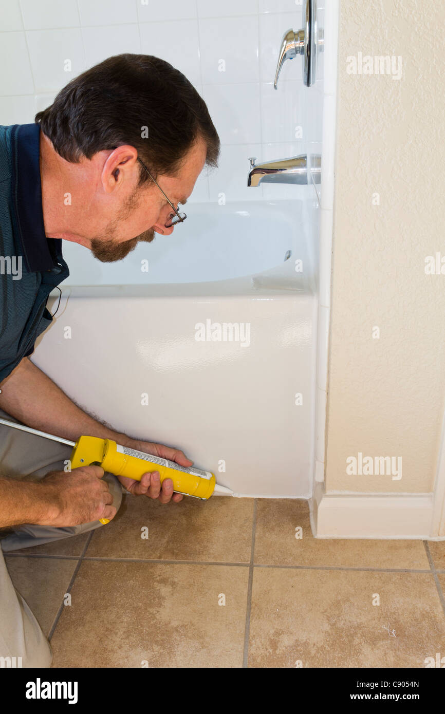 Contractor sealing tub base to keep water from seeping through the
