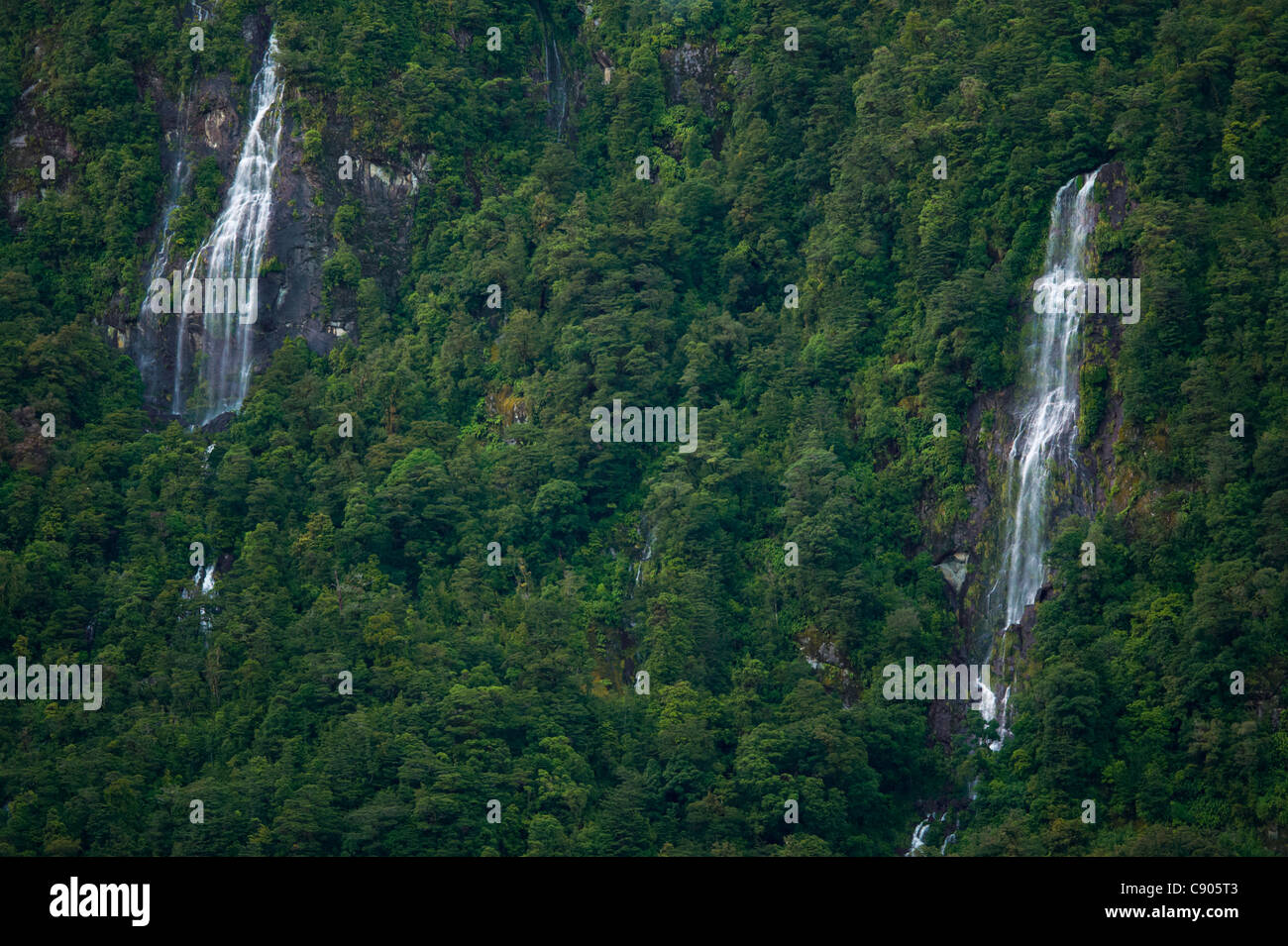 Cascading waterfalls on the steep rugged mountains of Doubtful Sound, Fiordland National Park, South Island, New Zealand Stock Photo