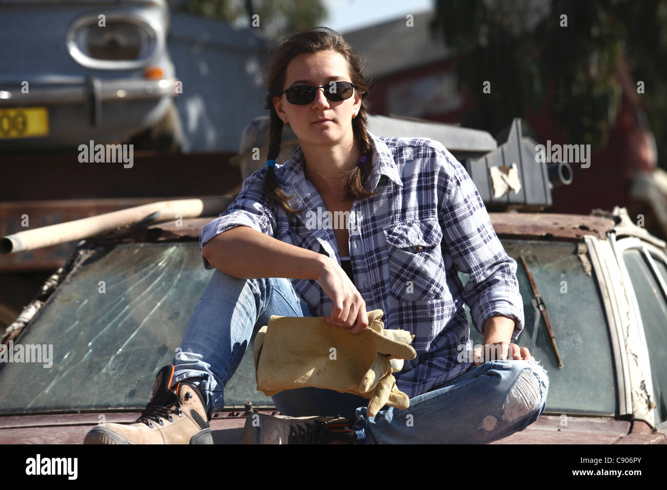 woman relaxing in a landfill after use auto Stock Photo