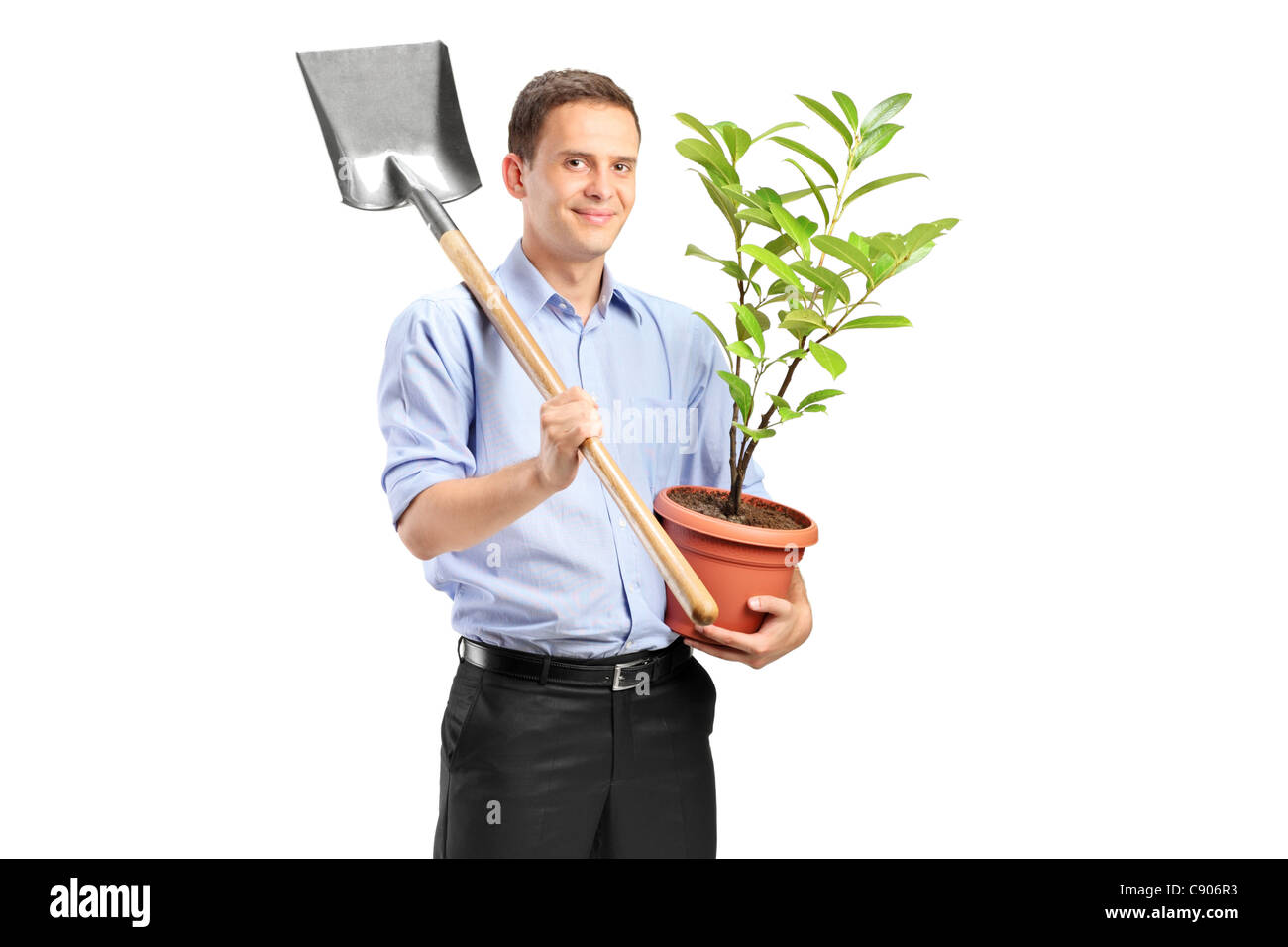 Smiling man holding a potted plant and a shovel Stock Photo - Alamy