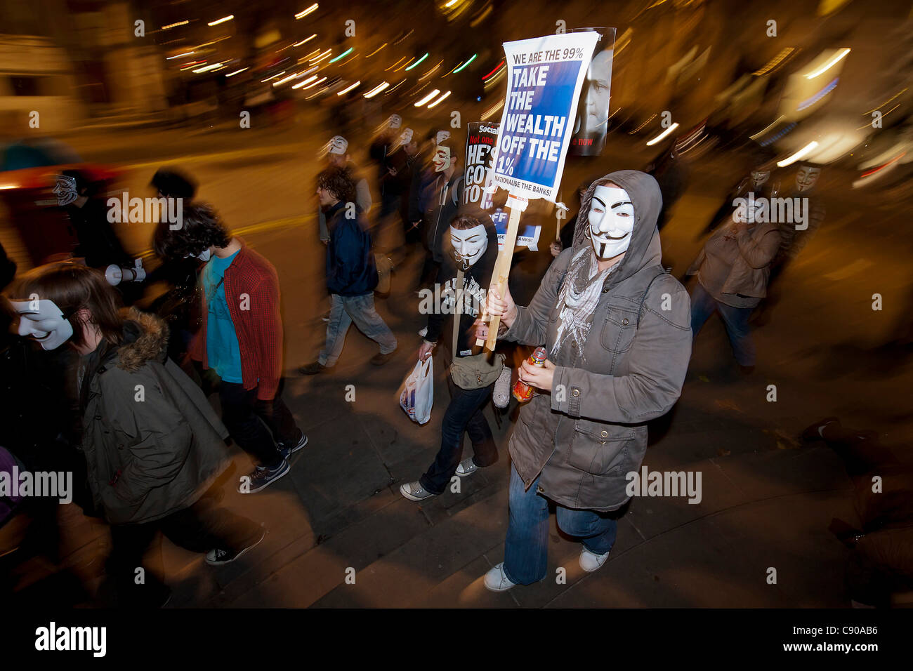 Followers of Anonymous UK arrive in Trafalgar Square sporting V for Vendetta masks. They dance and then march across the square Stock Photo