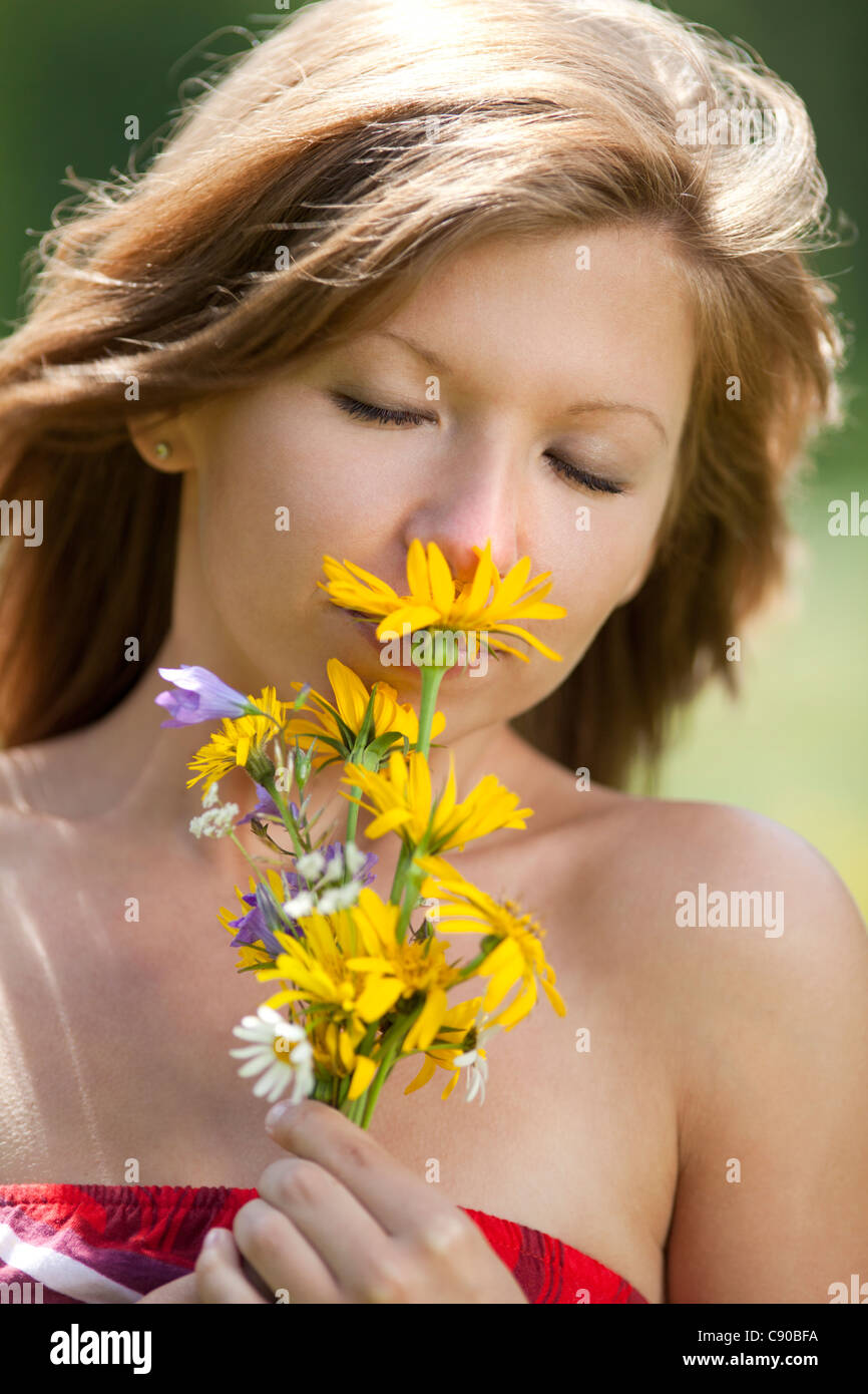 Girl smelling flowers Stock Photo - Alamy