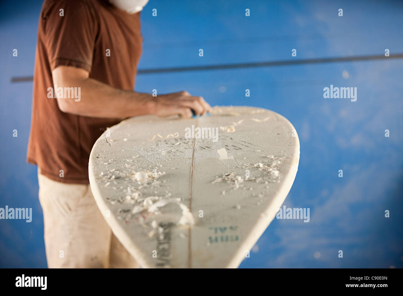 Man waxing surfboard Stock Photo