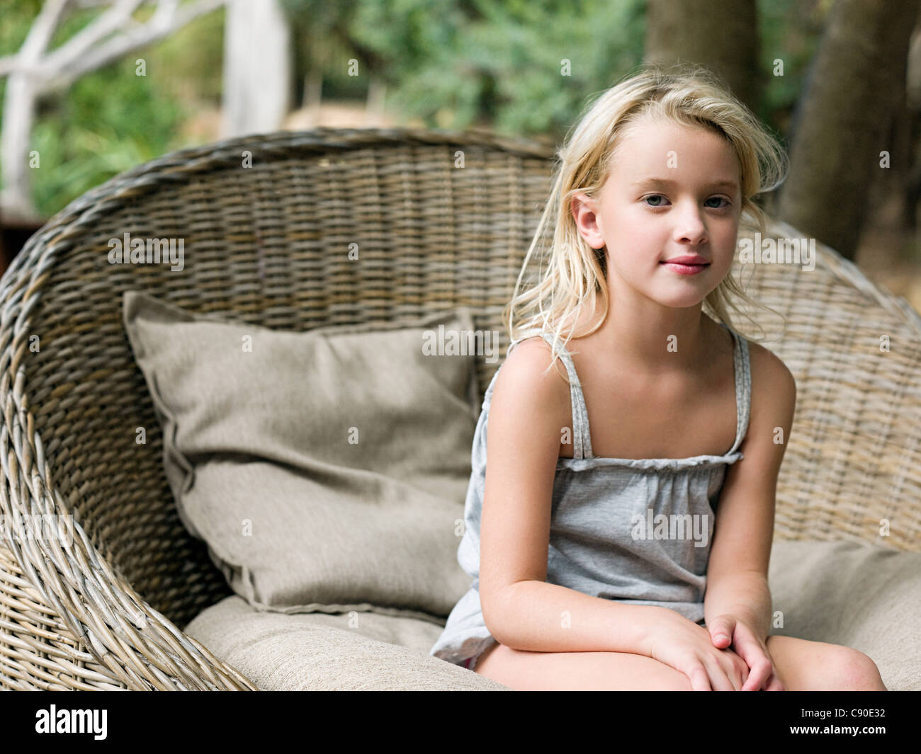 Girl sitting in wicker chair, portrait Stock Photo