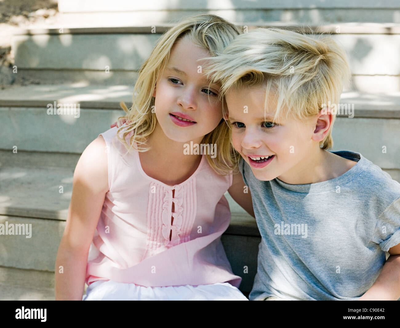 Brother and sister sitting on wooden steps Stock Photo