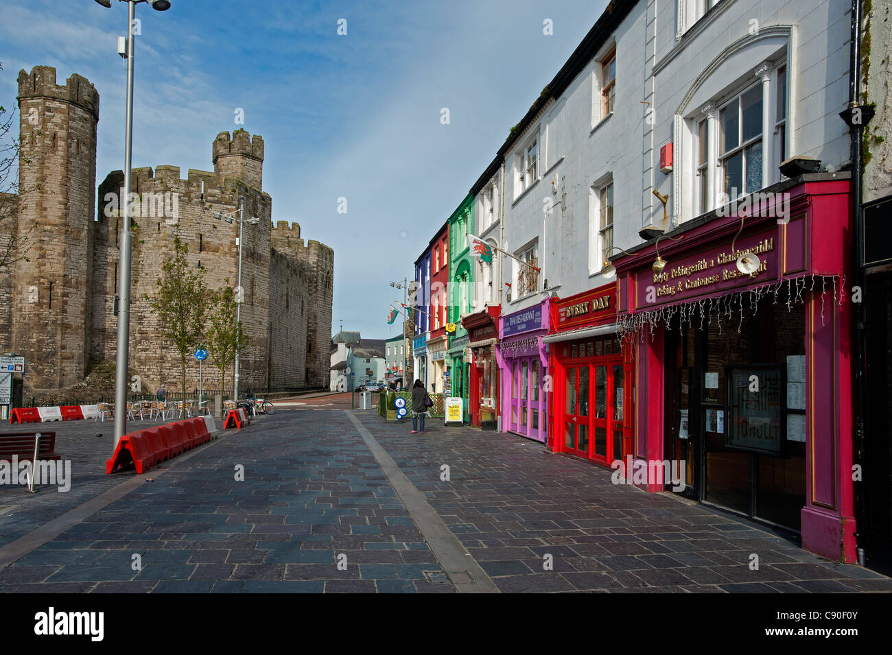 Caernarfon Castle with shops and restaurants, Caernarfon, Wales, UK