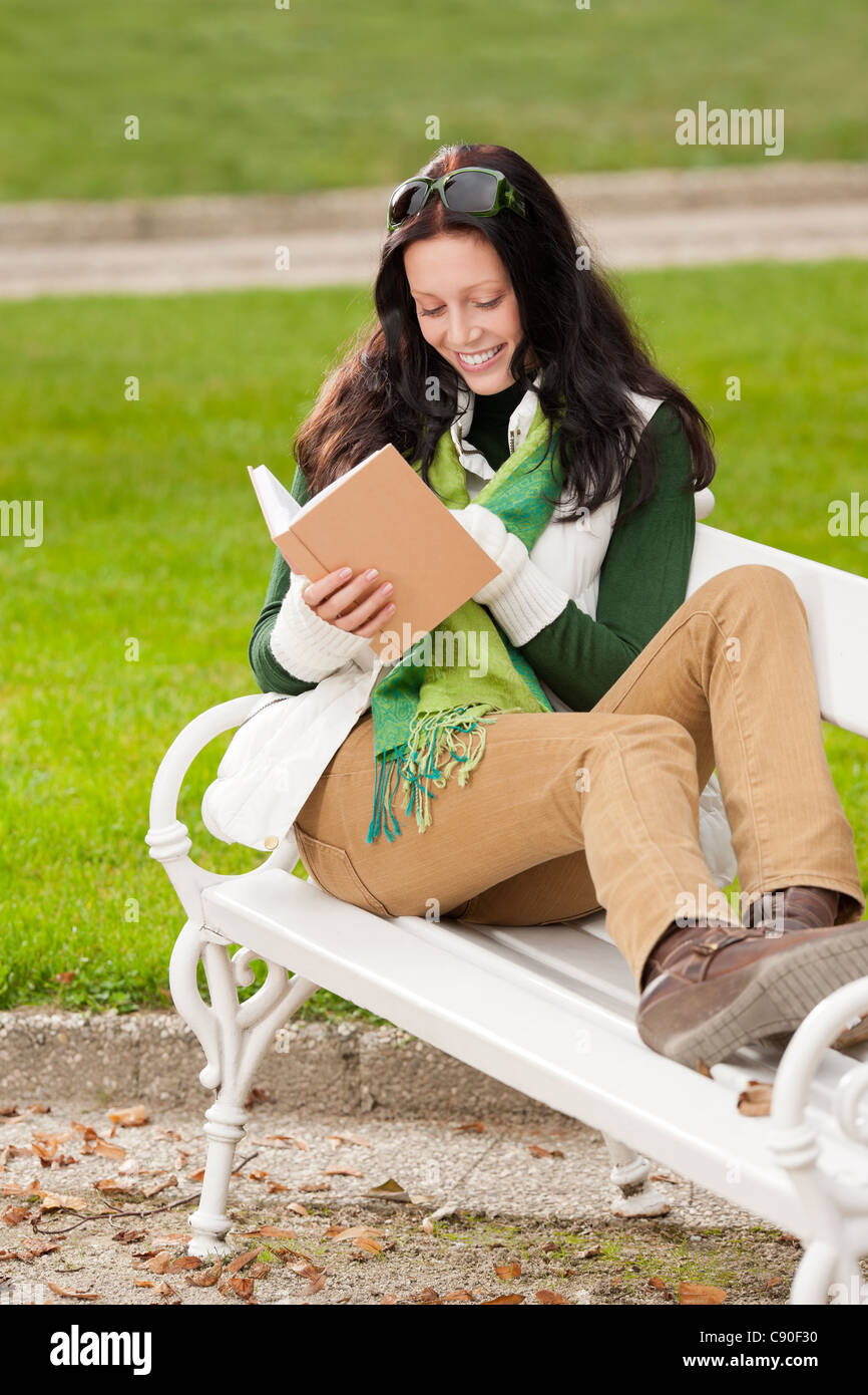 Autumn park young woman reading book sitting on the bench Stock Photo ...