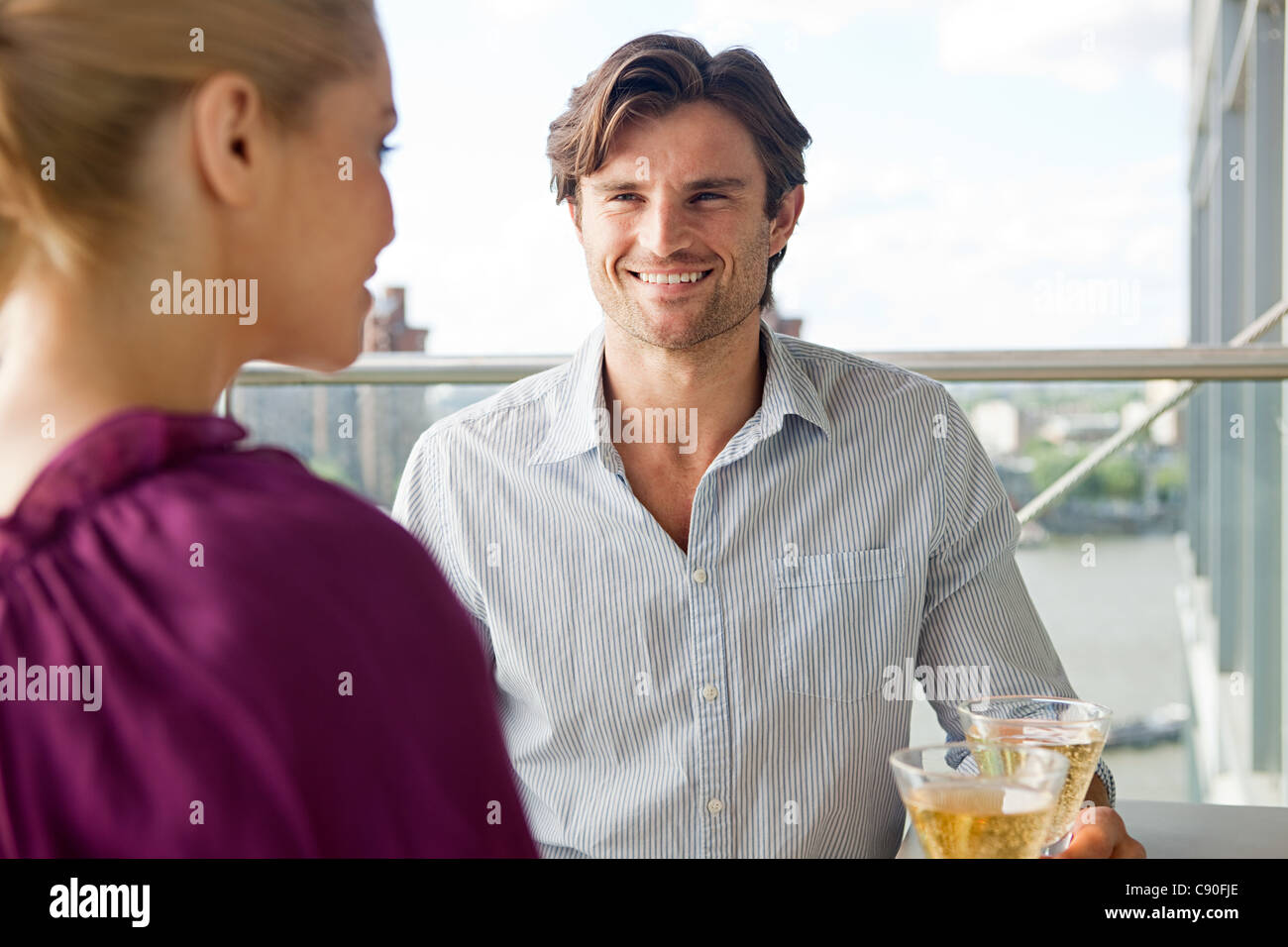 Couple on balcony with wine Stock Photo