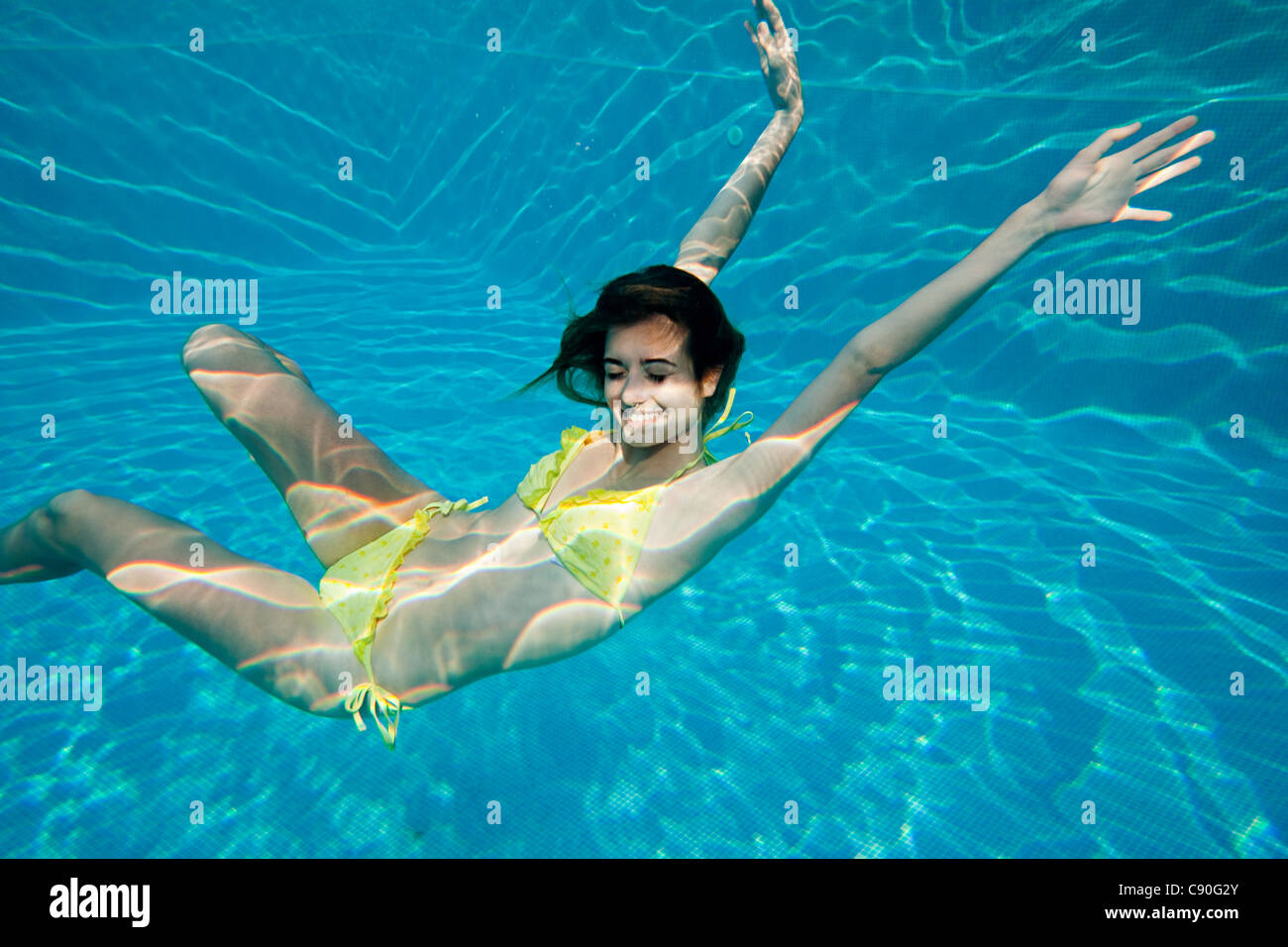 Young woman swimming underwater in swimming pool Stock Photo - Alamy, image size:1300x956