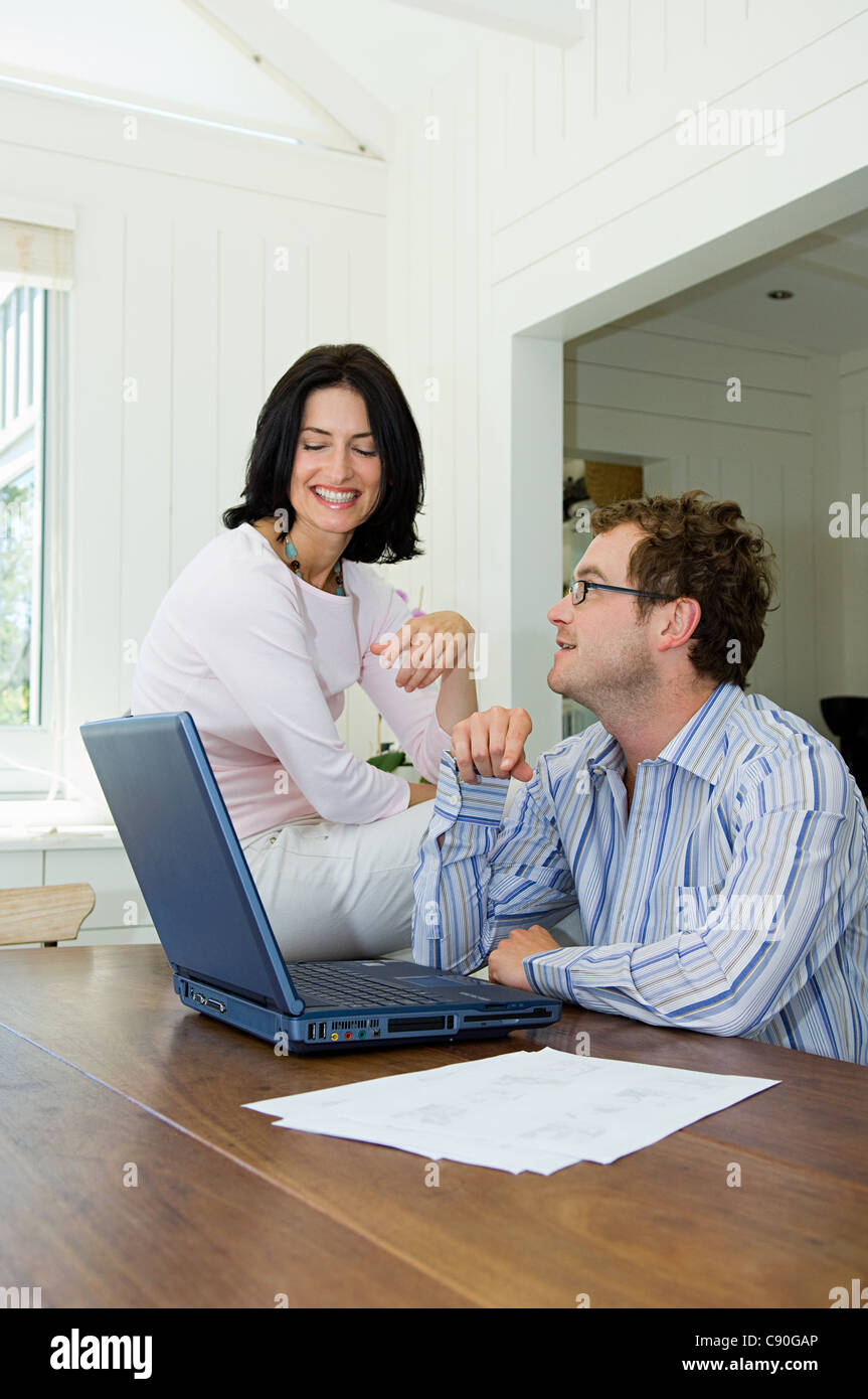 Couple using laptop in kitchen Stock Photo