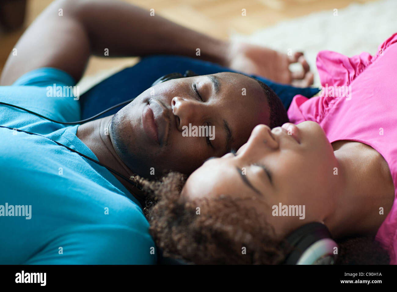 Man and woman listening to music, eyes closed Stock Photo
