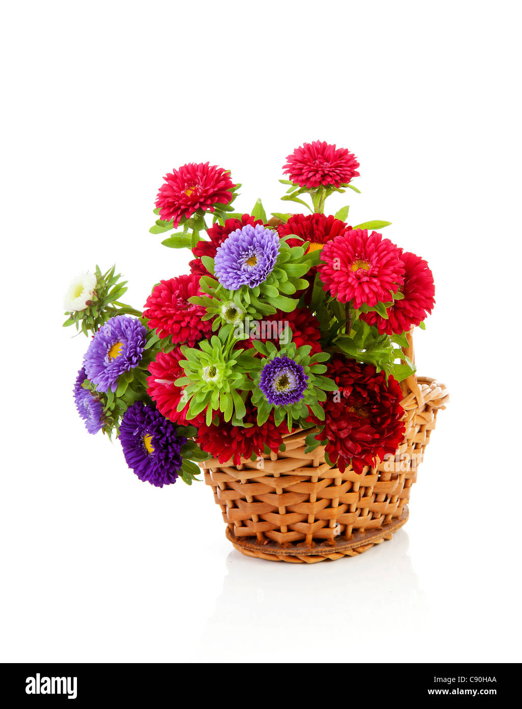 colorful Asters flowers in cane basket over white background Stock
