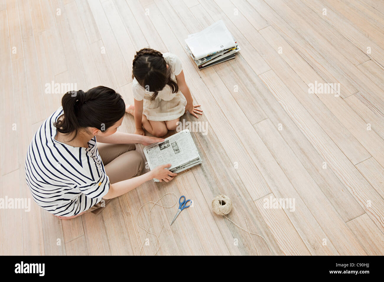 Mother and daughter with newspapers, high angle Stock Photo