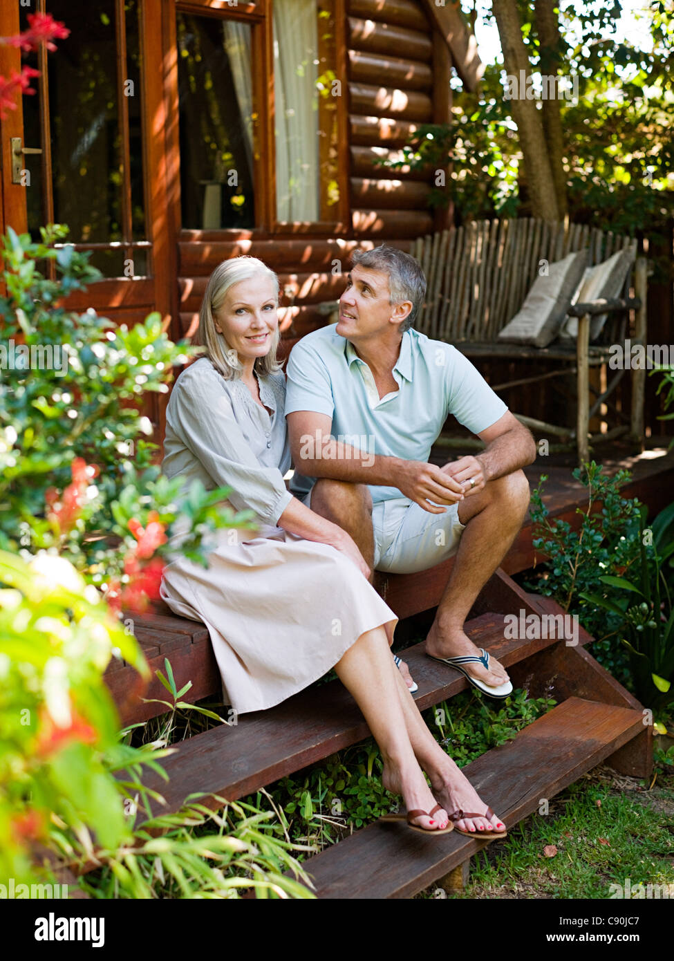 Couple sitting on porch steps in garden Stock Photo