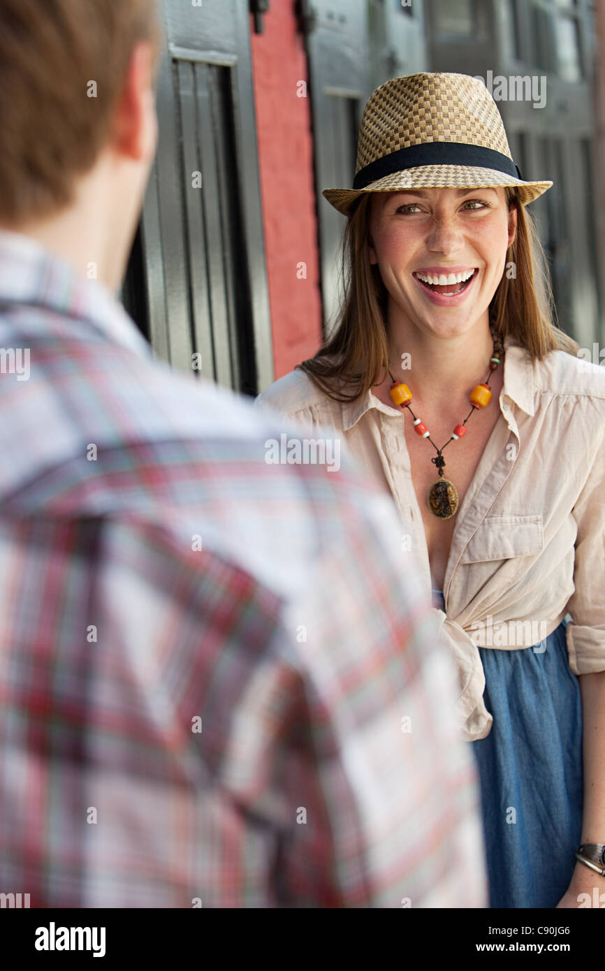 Young woman smiling at man outdoors Stock Photo