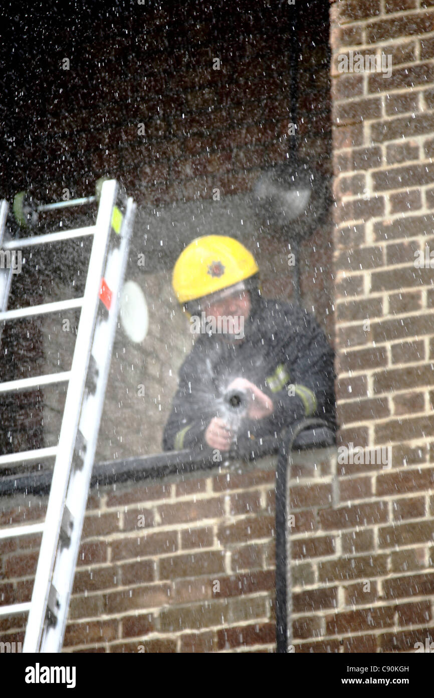 Fireman using a hose during a training exercise Stock Photo