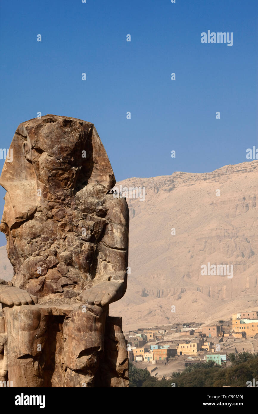 Coloss of Memnon with a nubian village, Luxor, ancient Thebes, Egypt, Africa Stock Photo