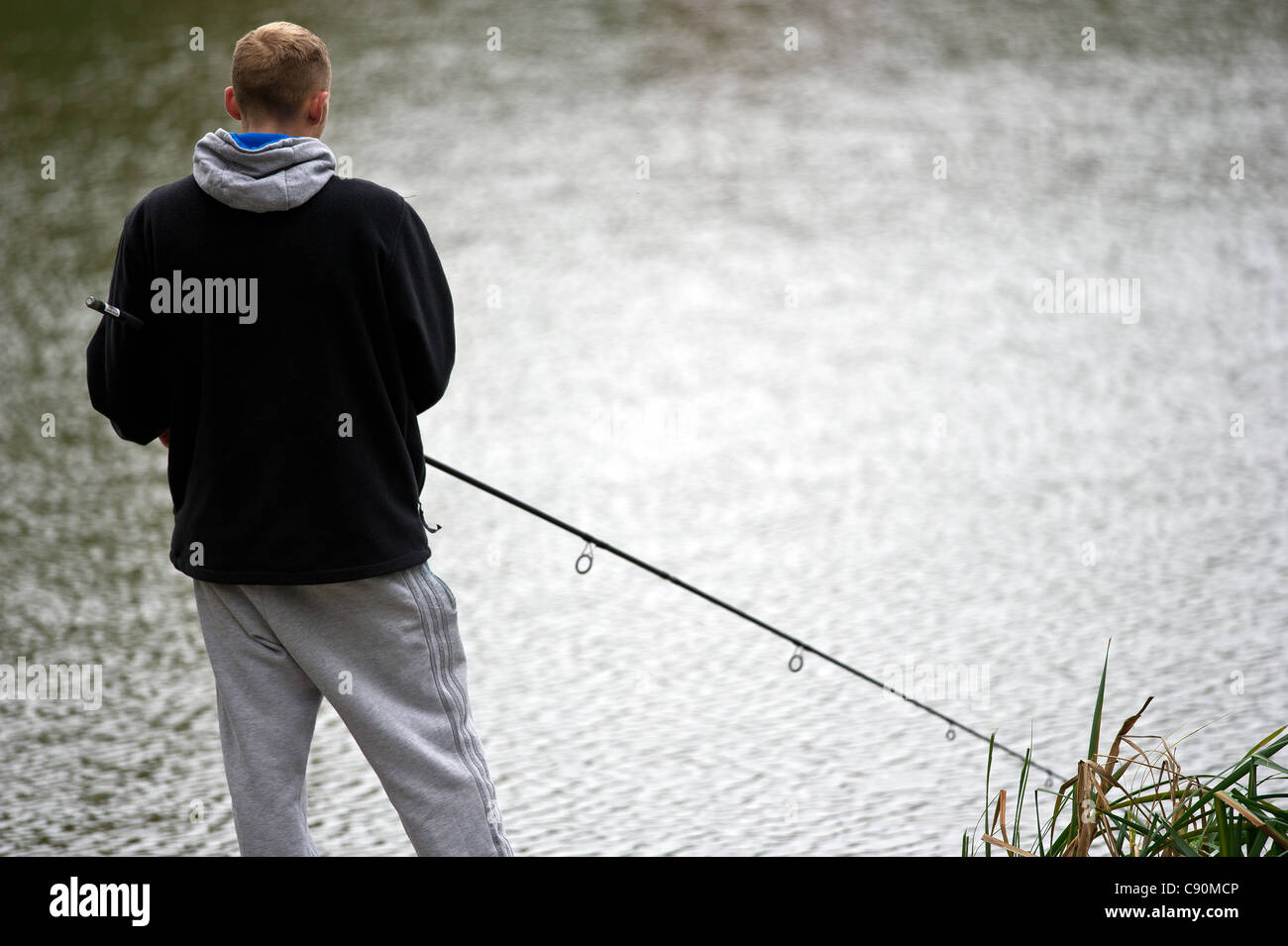 An angler fishing in a lake Stock Photo