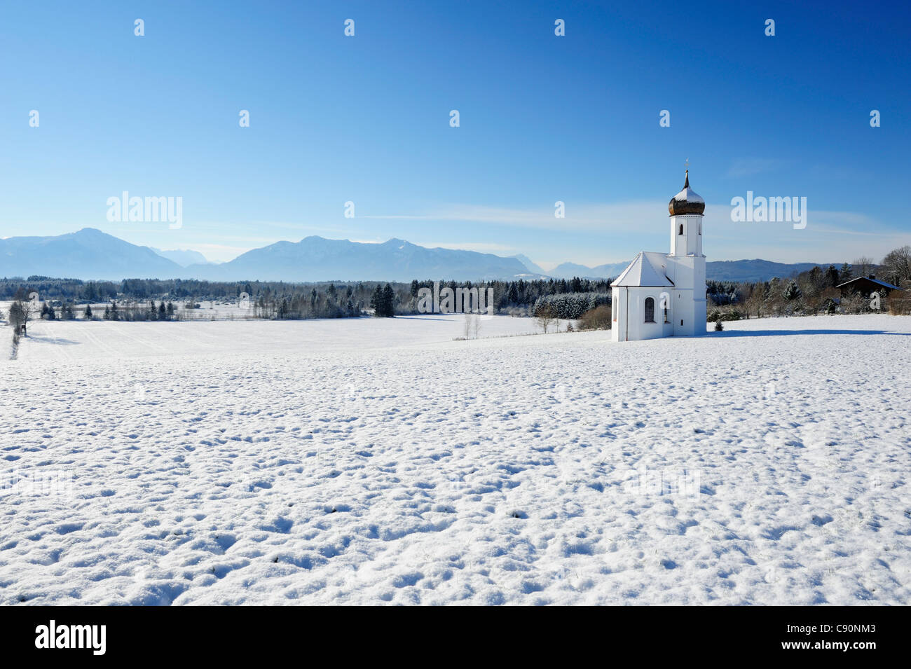 Snow covered church in front of range of Alps, Penzberg, Werdenfelser Land, Upper Bavaria, Bavaria, Germany, Europe Stock Photo