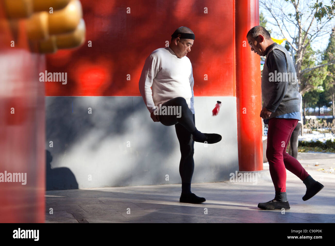 Morning sport in Jingshan Park two old men playing badminton with their feet red walls western gate Beijing People's Republic of Stock Photo