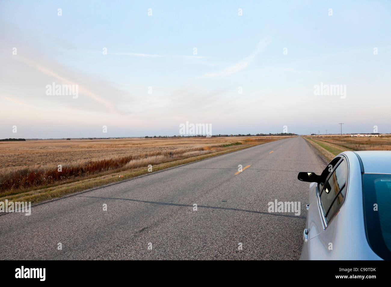 Parking car on a deserted road fields endless road highway in the mid
