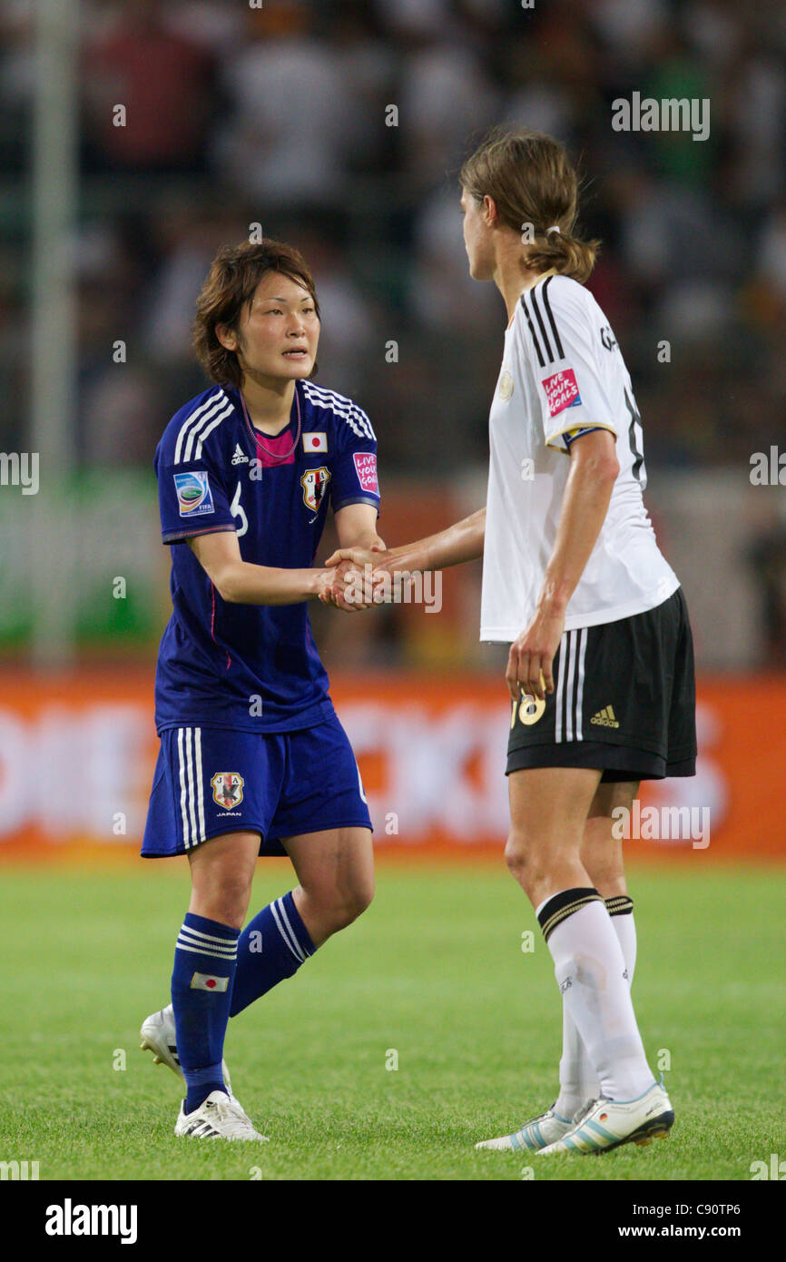 Mizuho Sakaguchi of Japan (L) and Kerstin Garefrekes of Germany shake hands after Japan defeated Germany in a World Cup match. Stock Photo