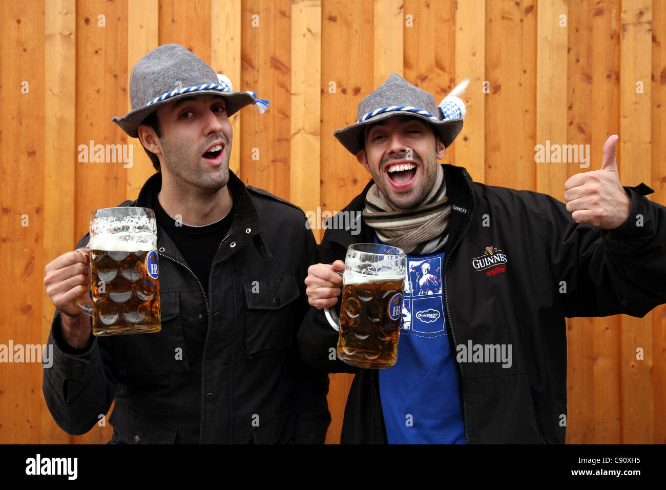 Happy visitors with traditional one litre beer masses at the Oktoberfest Beer Festival in Munich, Germany. Stock Photo