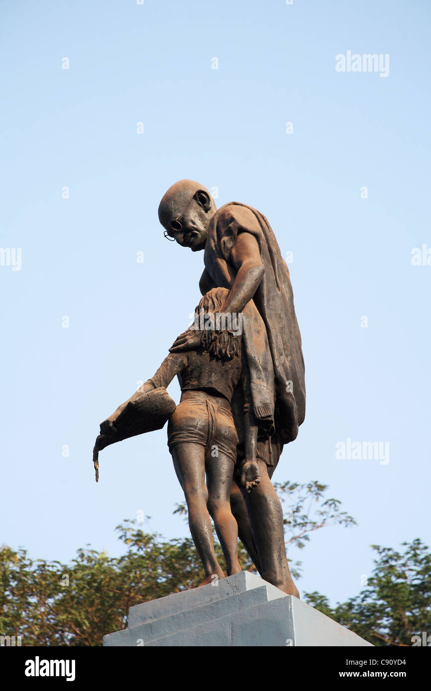There is a statue of the Indian national political leader Mahamtma Gandhi in customary loin cloth and spectacles comforting a Stock Photo