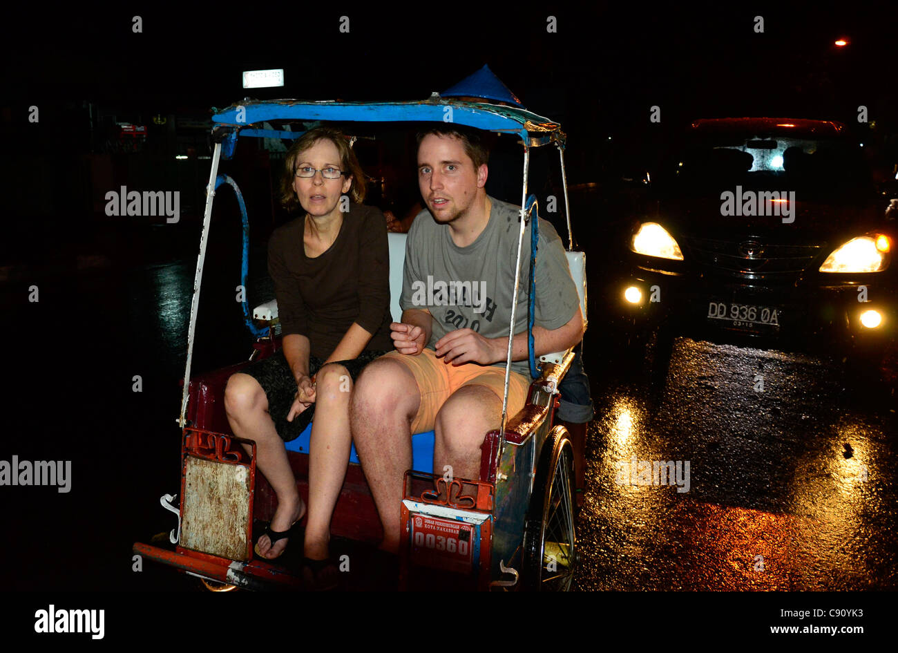 Mother and son on bicycle rickshaw called becak, Makassar, Indonesia. Stock Photo