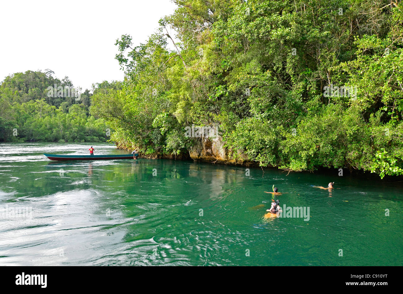 Tourists snorkelling in The Passage, Raja Ampat islands near West Papua, Indonesia in the coral triangle, Pacific Ocean. Stock Photo