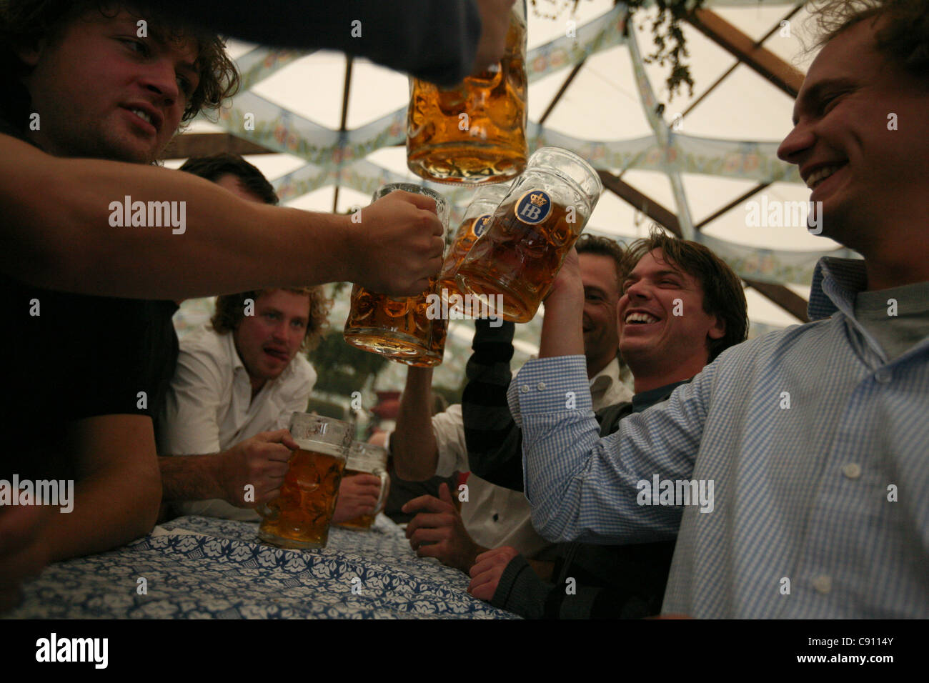 Company enjoys beer in the Hofbrau Festzelt at the Oktoberfest Beer Festival in Munich, Germany. Stock Photo