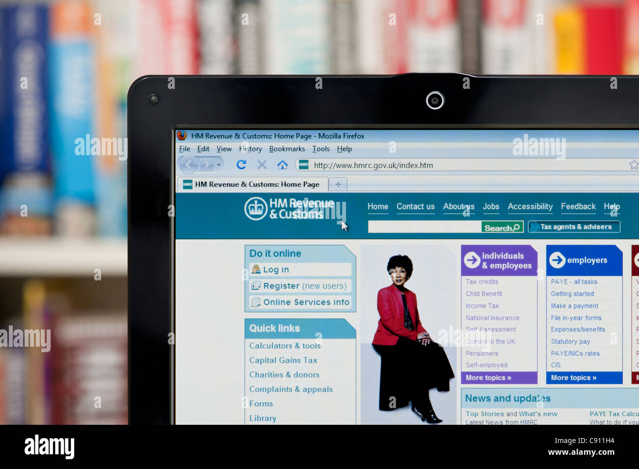 The HMRC website shot against a bookcase background (Editorial use only: print, TV, e-book and editorial website). Stock Photo