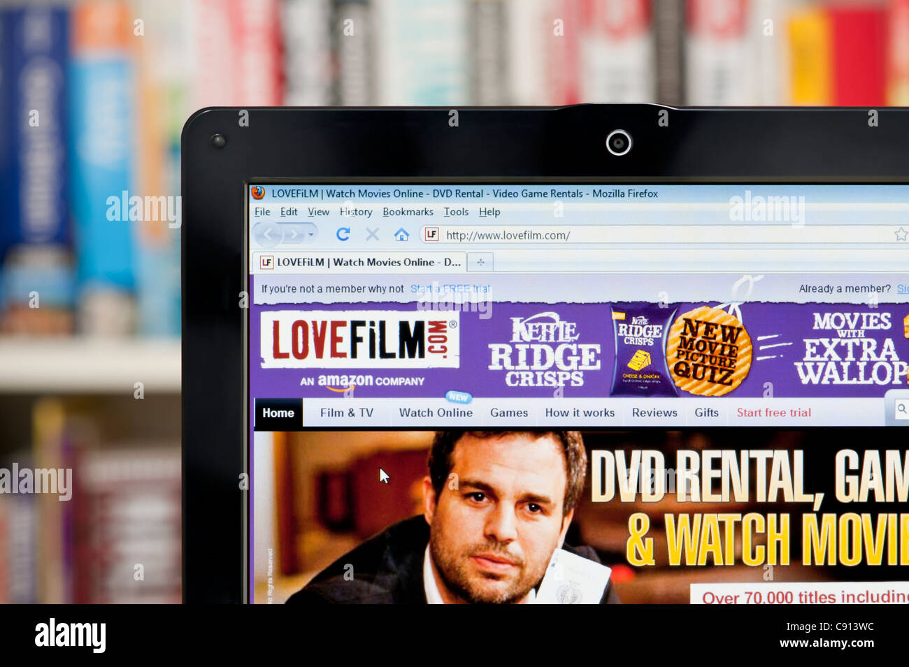 The LoveFilm website shot against a bookcase background (Editorial use only: print, TV, e-book and editorial website). Stock Photo
